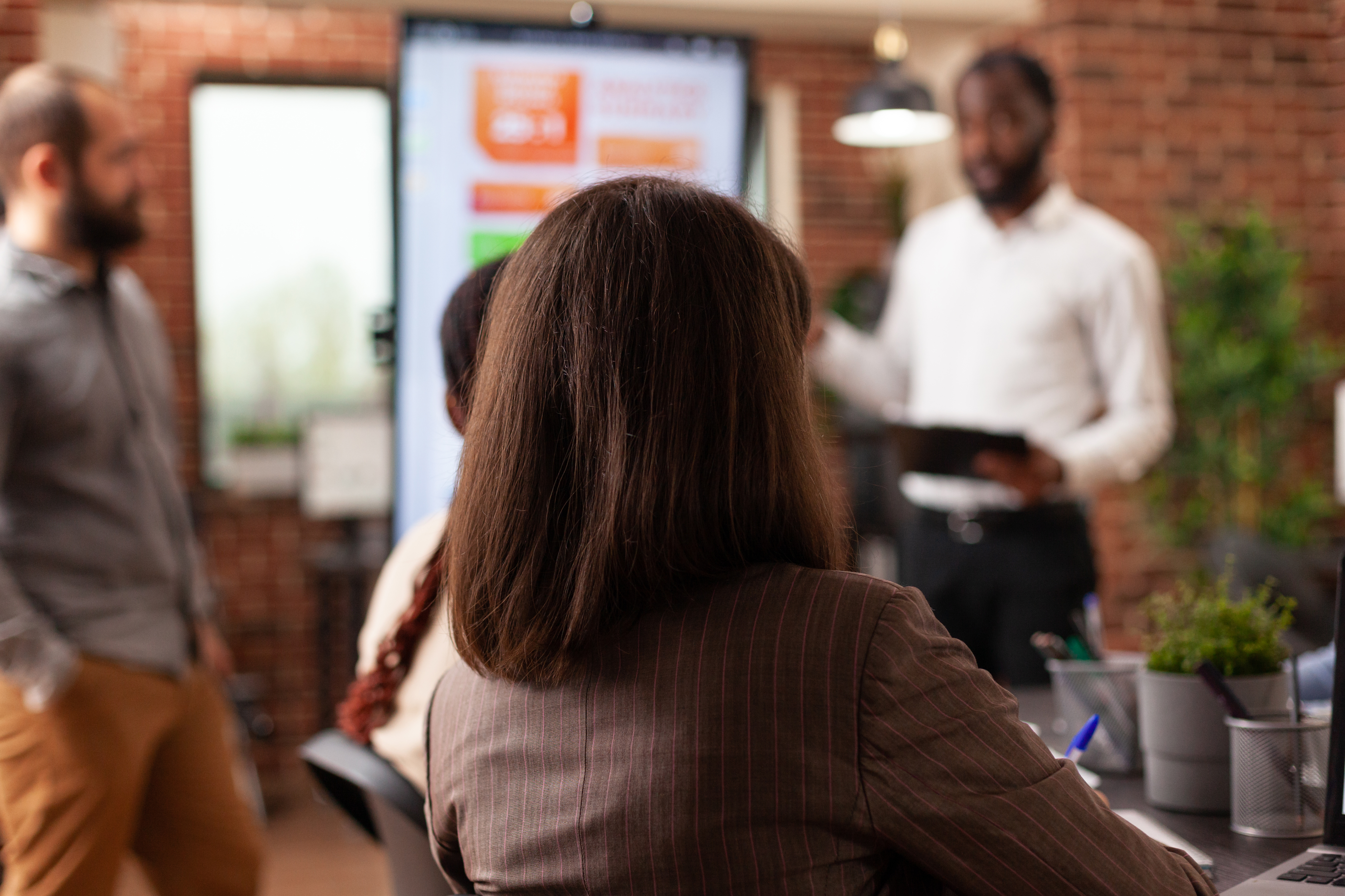 Entrepreneurs sitting at meeting table in startup company office brainstorming business ideas working at management presentation. Businesspeople discussing financial strategy at workplace